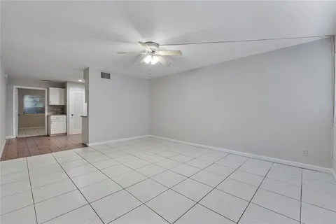 an empty room with fan and entrance