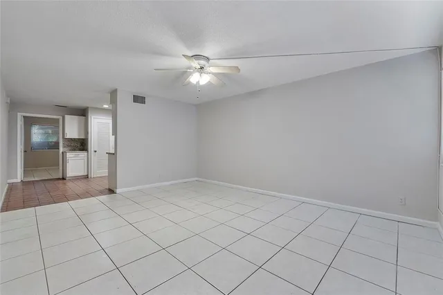 an empty room with fan and entrance