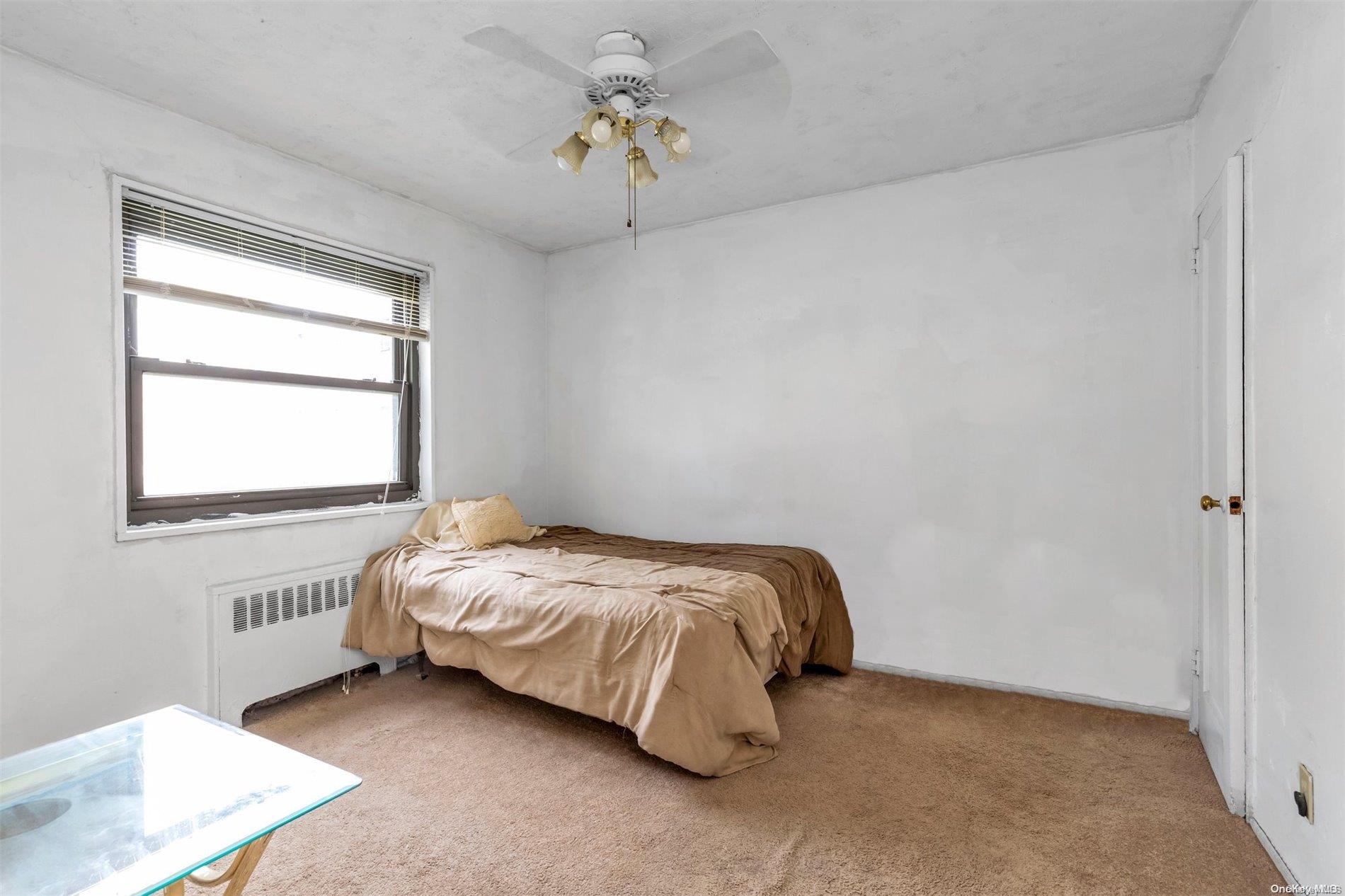 160-51 17th Avenue, Unit LOWR Queens, NY 11357 - Photo 10 of 16 a bed sitting in a bedroom next to a window