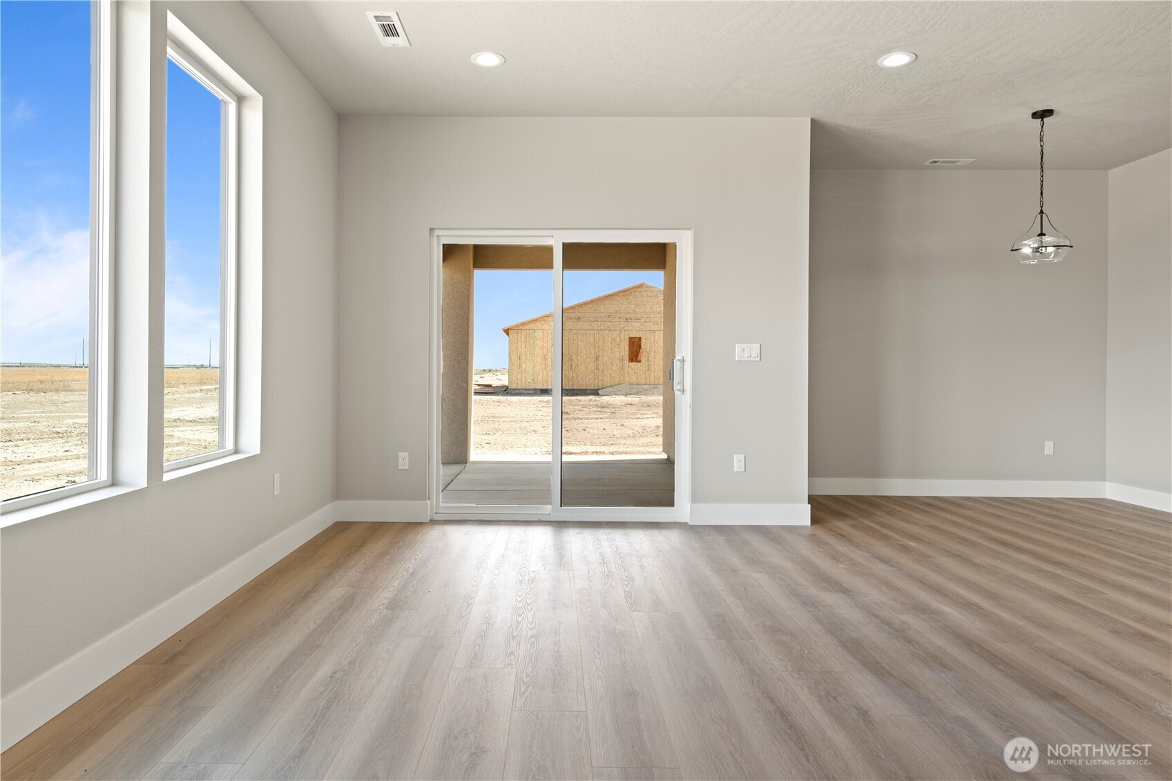 1249 E Mount Othello, WA 99344 - Photo 11 of 33 a view of an empty room with wooden floor and a window