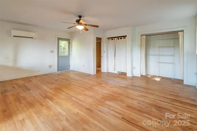 a view of empty room with window and ceiling fan