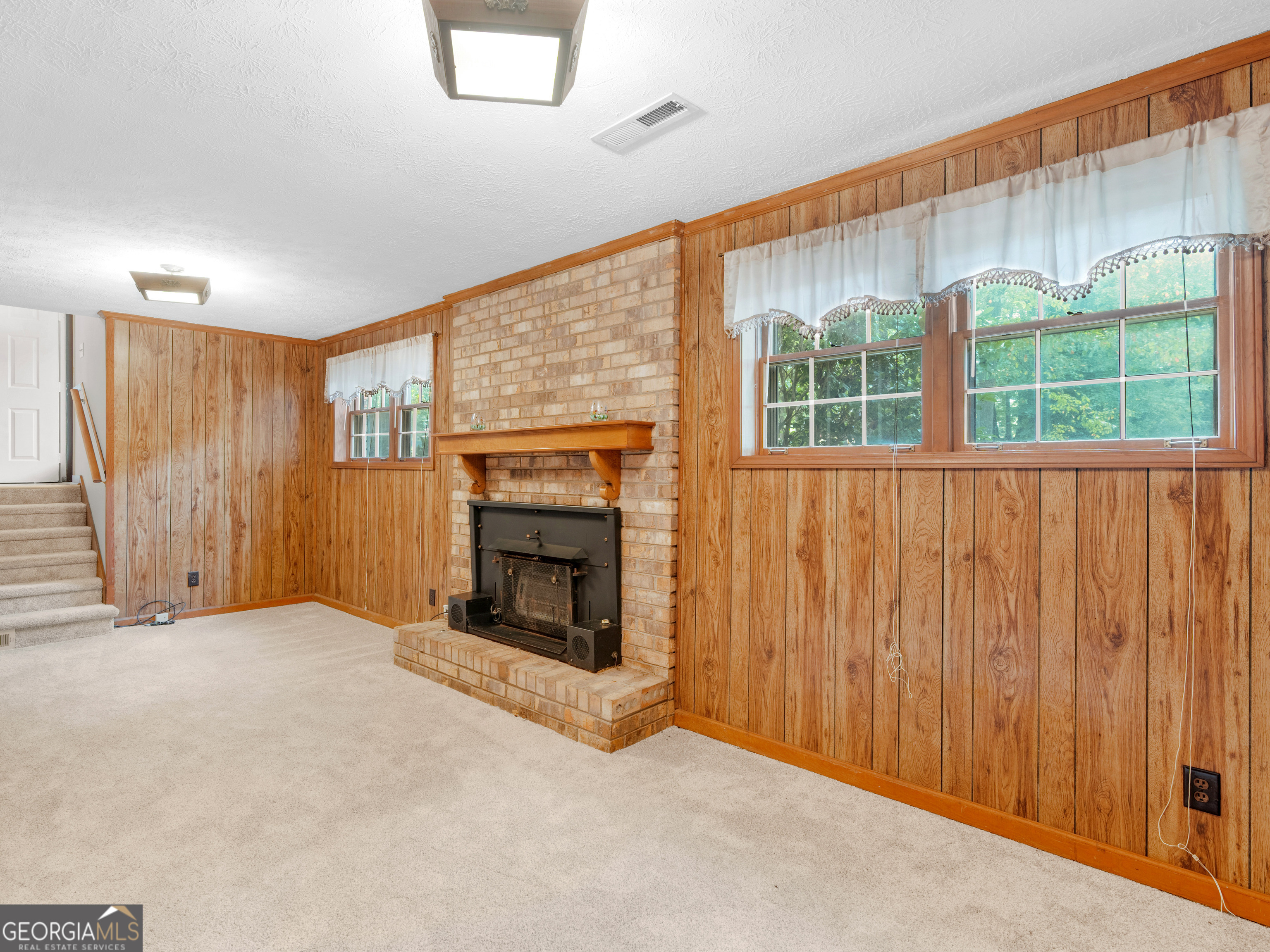 8294 Winston Way Jonesboro, GA 30236 - Photo 24 of 62 an empty room with windows a fireplace and garden view