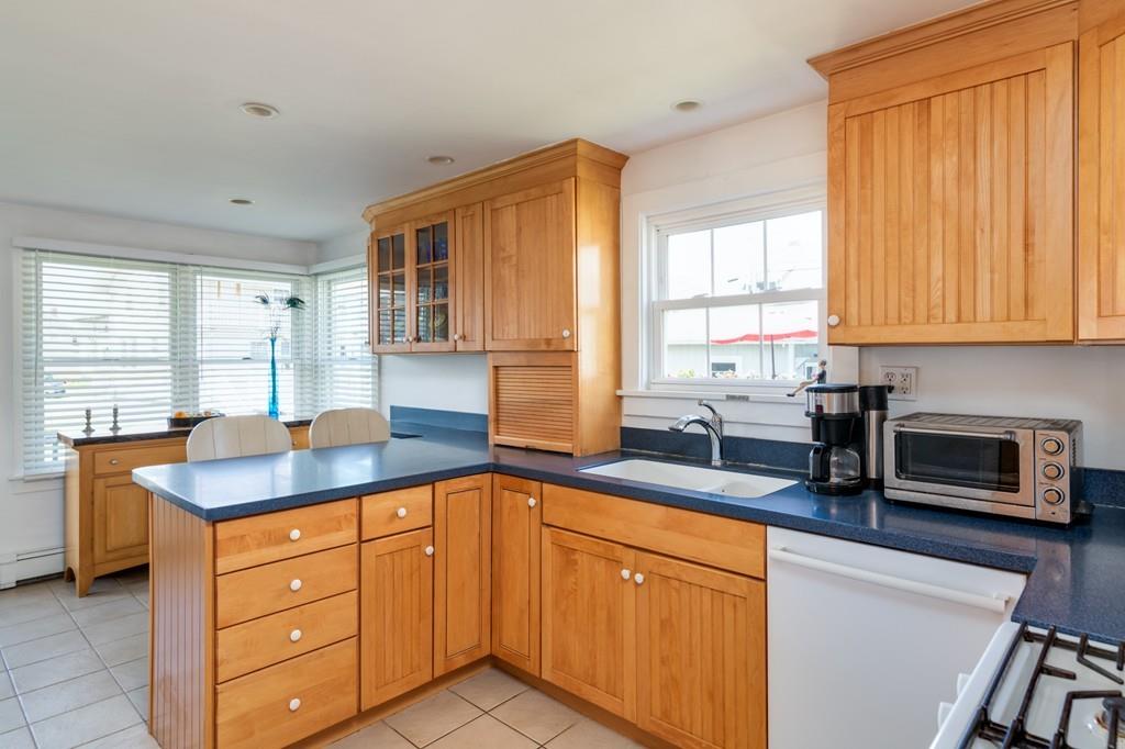 7 Mildred Street Hull, MA 02045 - Photo 14 of 26 a kitchen with stainless steel appliances granite countertop wooden cabinets a sink and a window