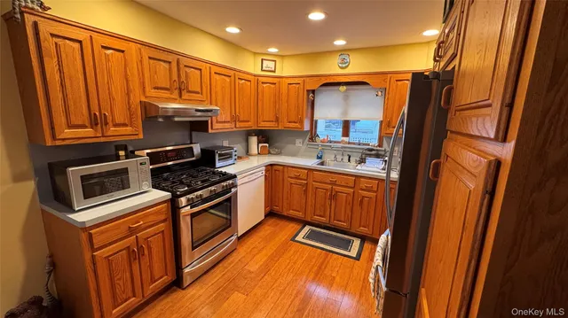 a kitchen with stainless steel appliances granite countertop a refrigerator and a stove top oven