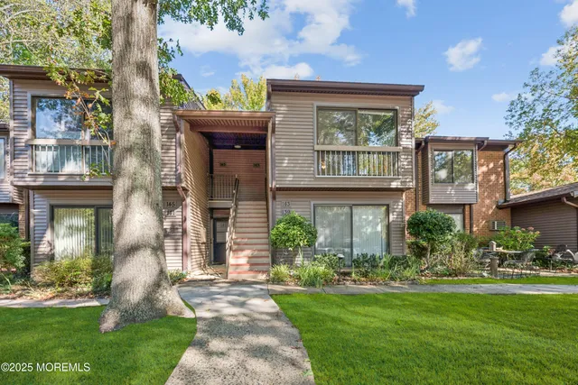 a front view of a house with garden and plants