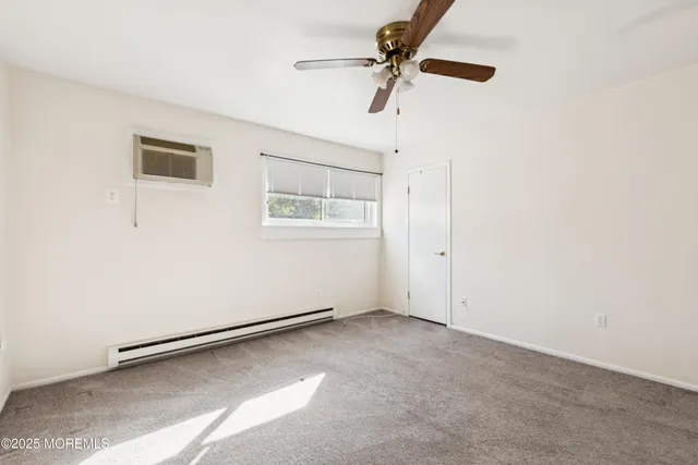 an empty room with a ceiling fan and a window