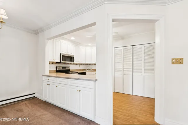 a kitchen with white cabinets and sink