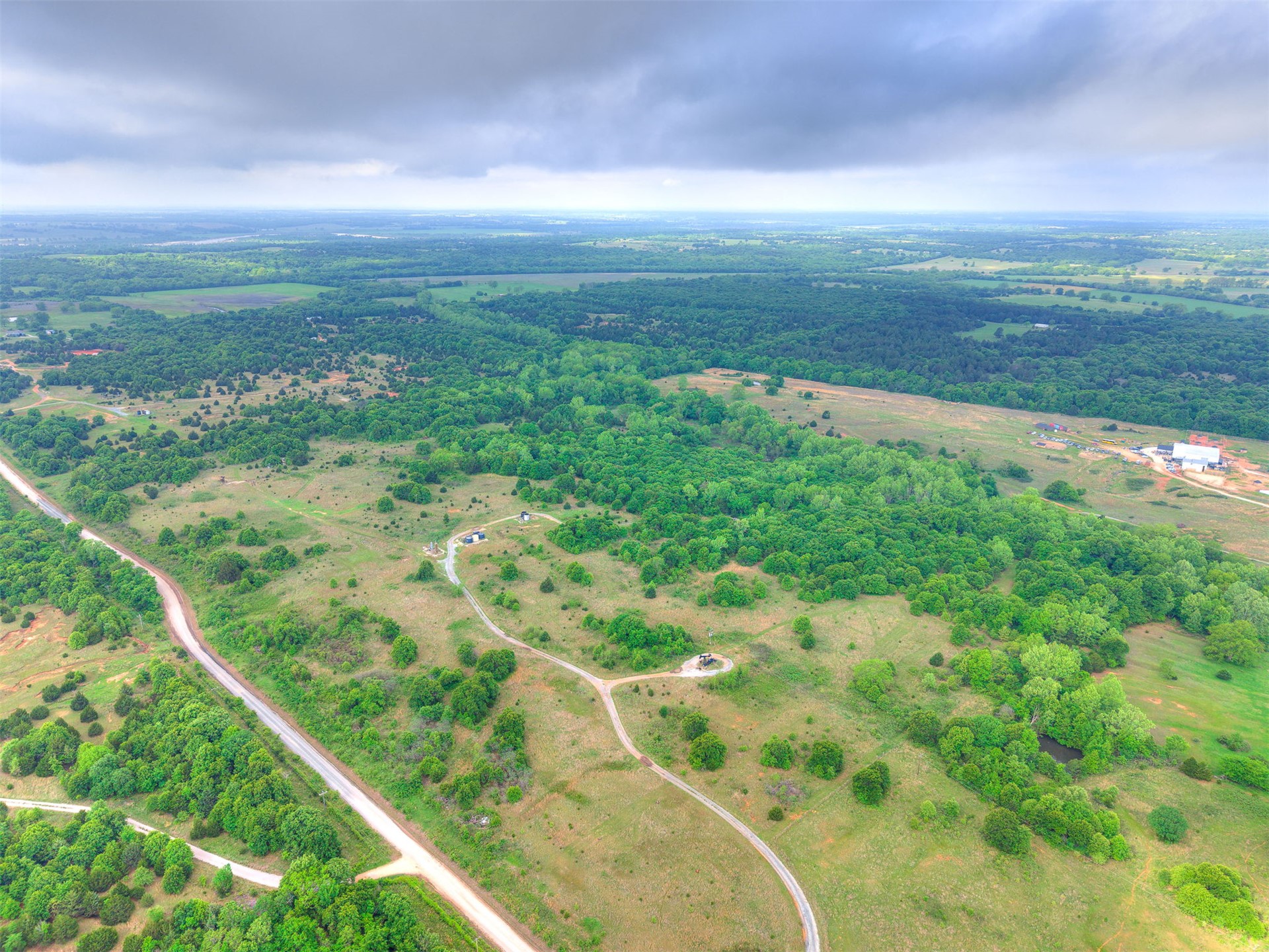 3 Patterson Road Wanette, OK 74878 - Photo 5 of 8 Expansive acreage featuring abundant mature trees, open grassy areas, and a visible roadway