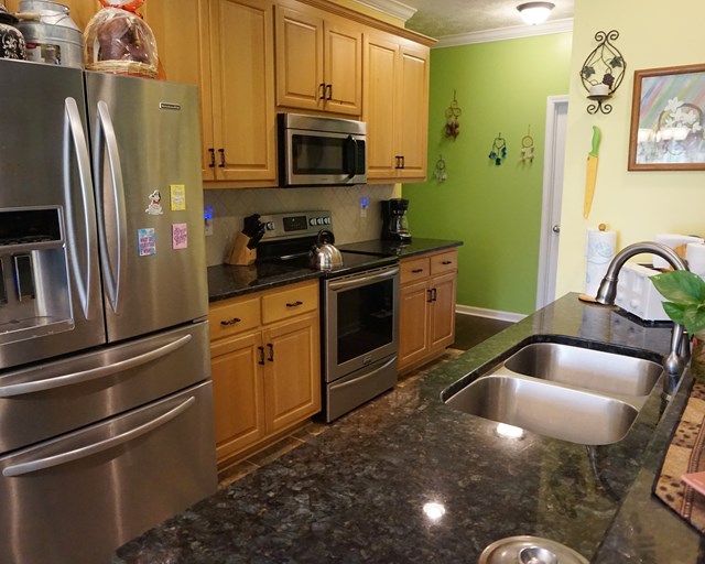 37 Copper Road Seale, AL 36875 - Photo 25 of 42 a kitchen with stainless steel appliances granite countertop a sink a stove and a refrigerator