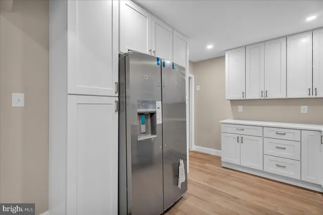 a kitchen with white cabinets and stainless steel appliances