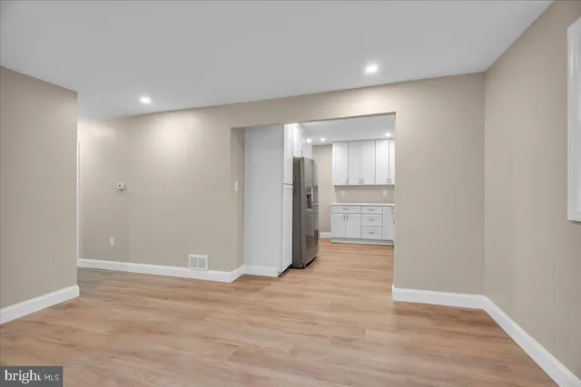 a view of an empty room with wooden floor and closet