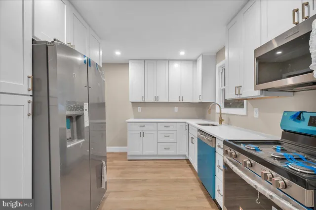 a kitchen with stainless steel appliances granite countertop a refrigerator and a stove top oven