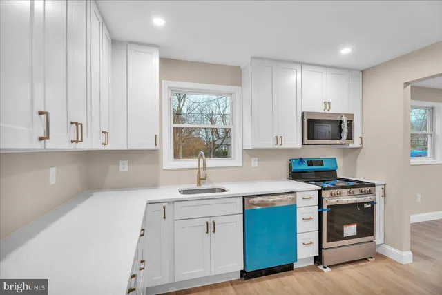 a kitchen with granite countertop white cabinets stainless steel appliances and sink