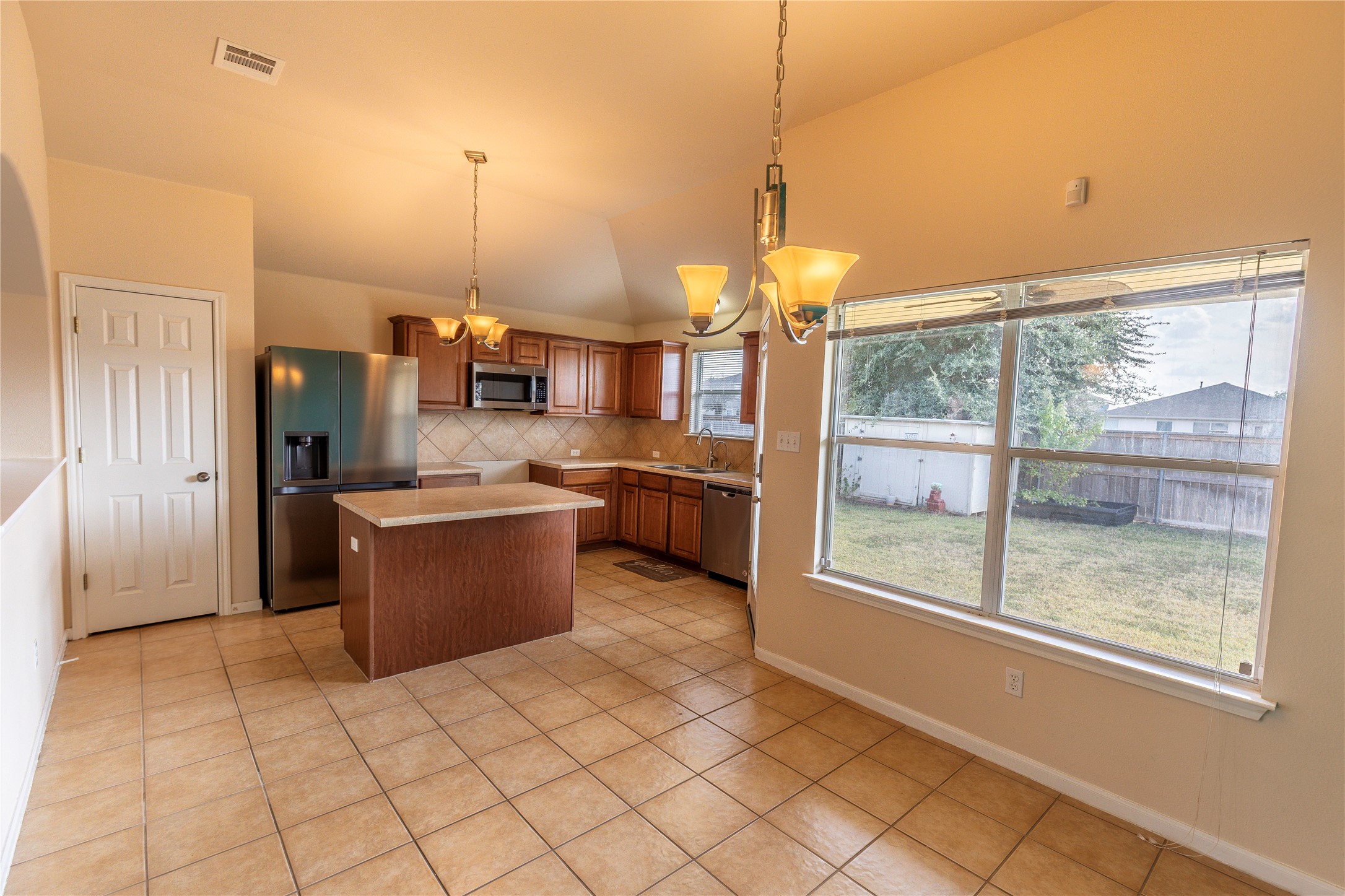 102 Thompson Trail Bastrop, TX 78602 - Photo 6 of 18 a kitchen with stainless steel appliances kitchen island granite countertop a refrigerator a oven and a sink with granite countertops