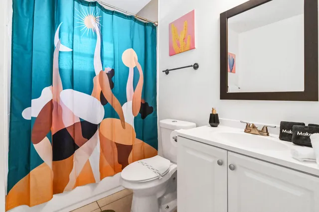a bathroom with a sink mirror vanity and toilet