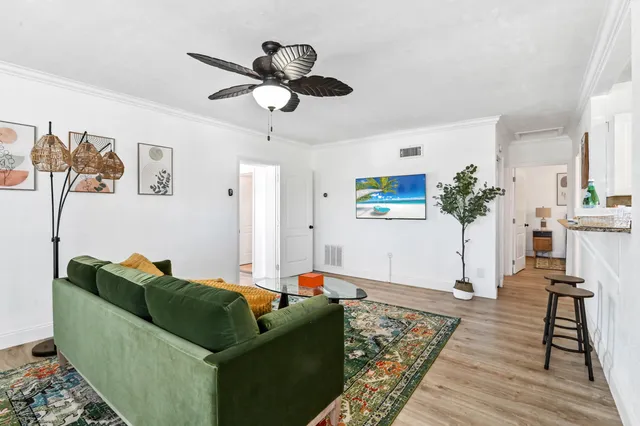 a living room with furniture and a wooden floor