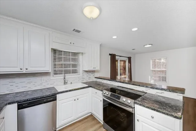 a kitchen with a refrigerator sink and cabinets