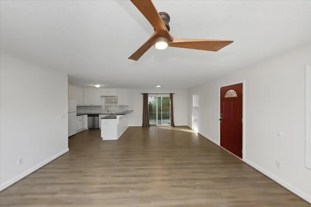 a view of an empty room with window and wooden floor