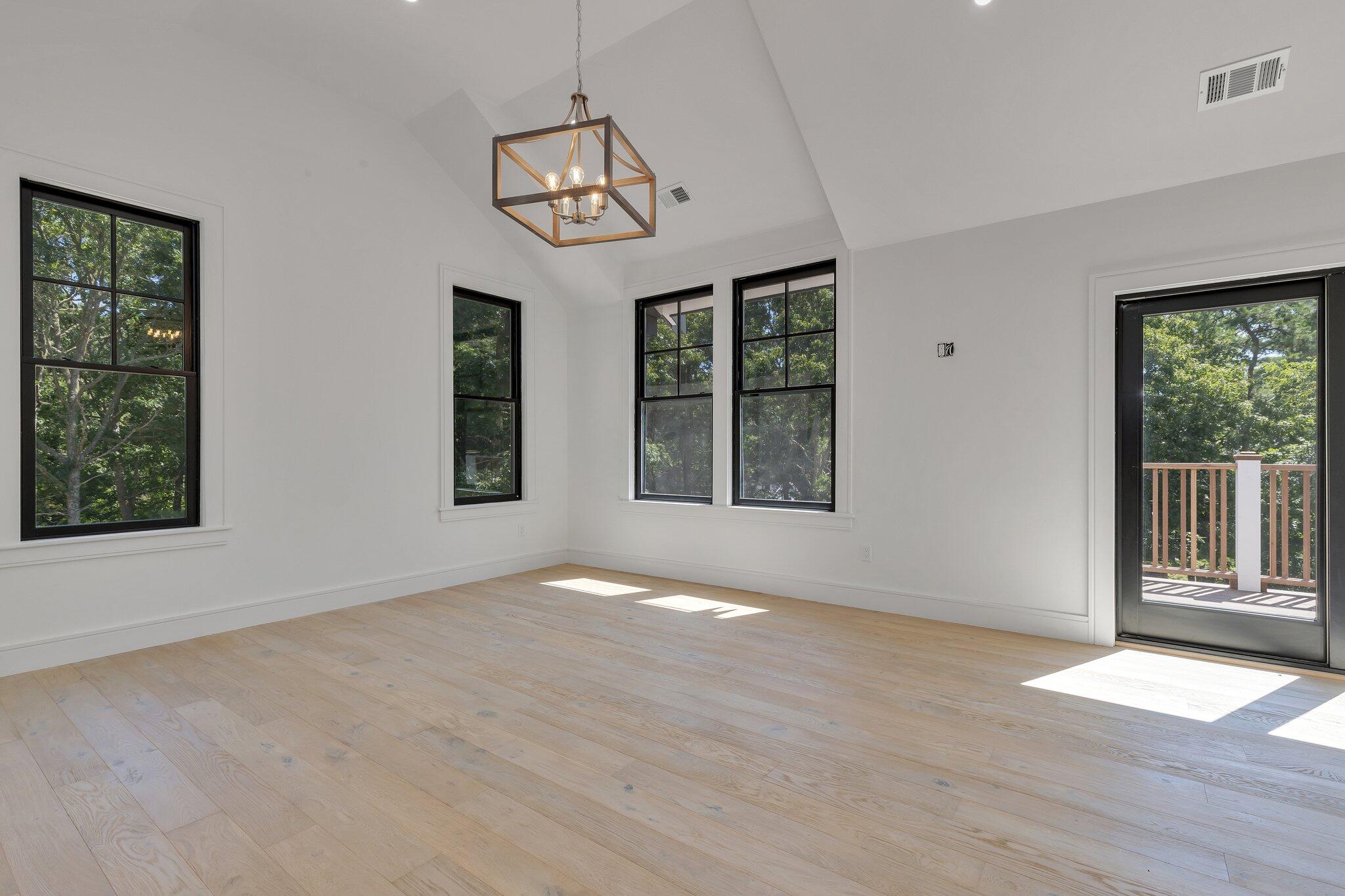 72 5 Corners Road Centerville, MA 02632 - Photo 26 of 48 an empty room with wooden floor fan and windows