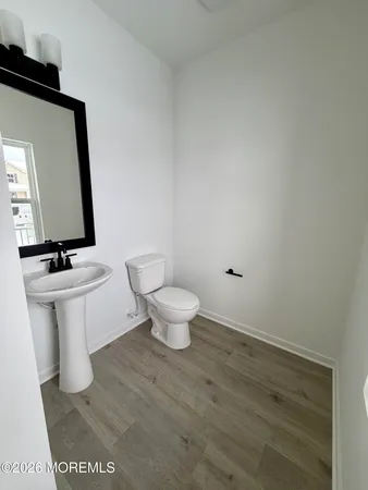 a bathroom with a toilet a sink and mirror