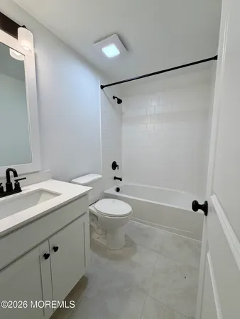 a bathroom with a granite countertop sink mirror vanity and toilet
