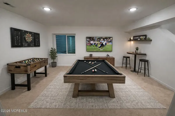a room with furniture pool table and wall paintings