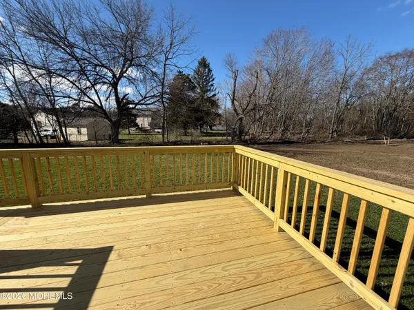 a view of deck with large trees and wooden fence