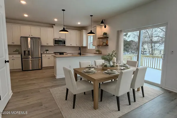 a view of a dining room with furniture a chandelier and wooden floor