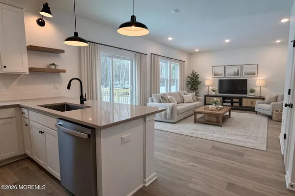 a kitchen with stainless steel appliances granite countertop a sink a stove and a wooden floors