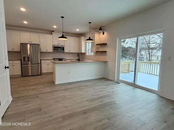 a kitchen with stainless steel appliances a refrigerator and wooden floor
