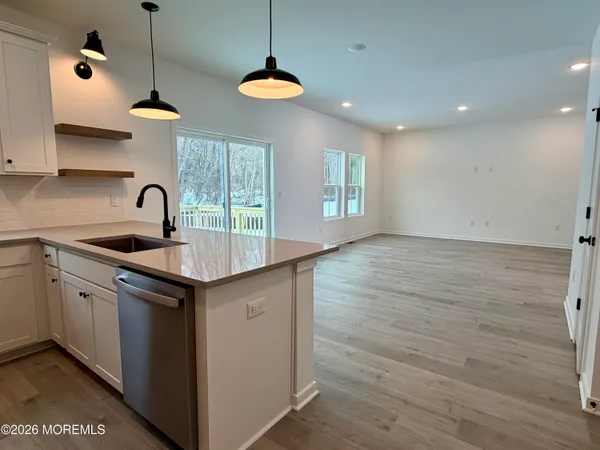 a kitchen with kitchen island granite countertop a sink a counter space appliances and cabinets