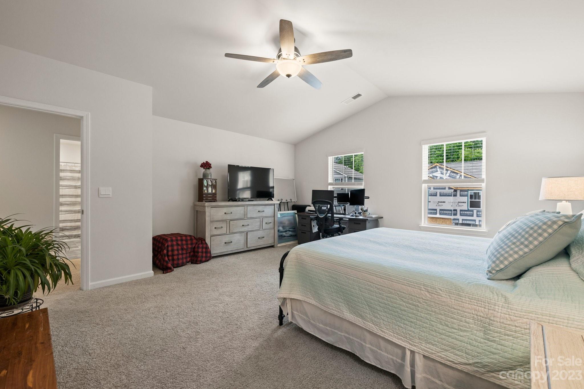 38 Hamrick Drive Candler, NC 28715 - Photo 19 of 37 a spacious bedroom with a bed a couch and a potted plant