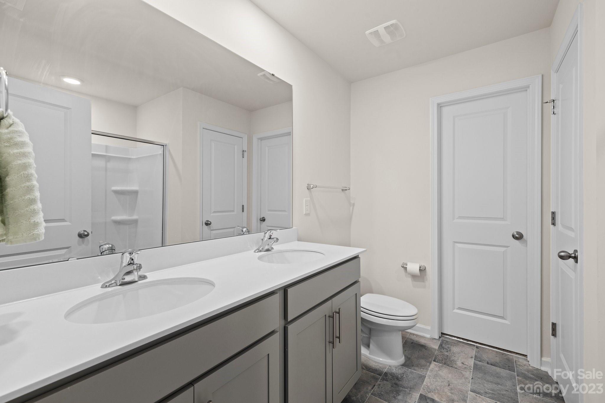 38 Hamrick Drive Candler, NC 28715 - Photo 20 of 37 a bathroom with a granite countertop sink a toilet and a large mirror