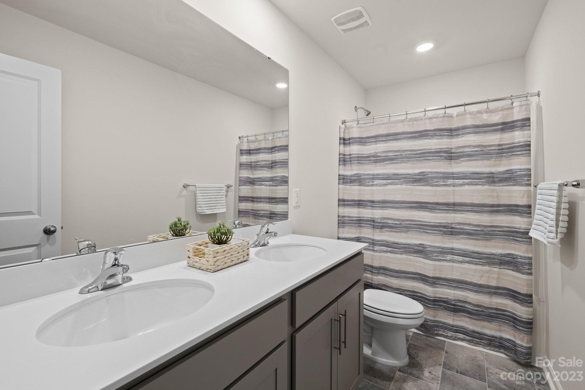 38 Hamrick Drive Candler, NC 28715 - Photo 25 of 37 a bathroom with a double vanity sink toilet and a mirror