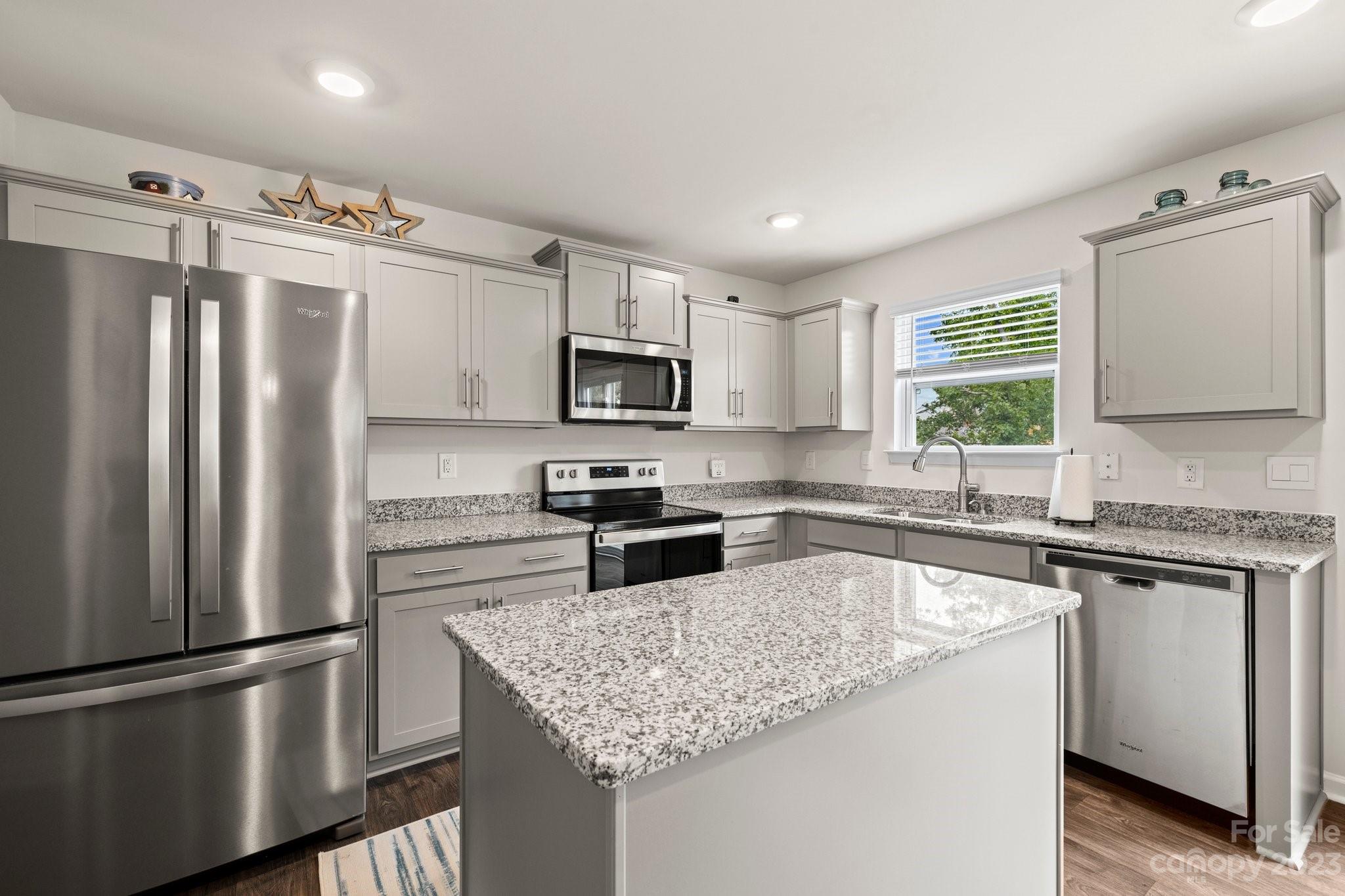 38 Hamrick Drive Candler, NC 28715 - Photo 5 of 37 a kitchen with granite countertop a refrigerator stove and microwave