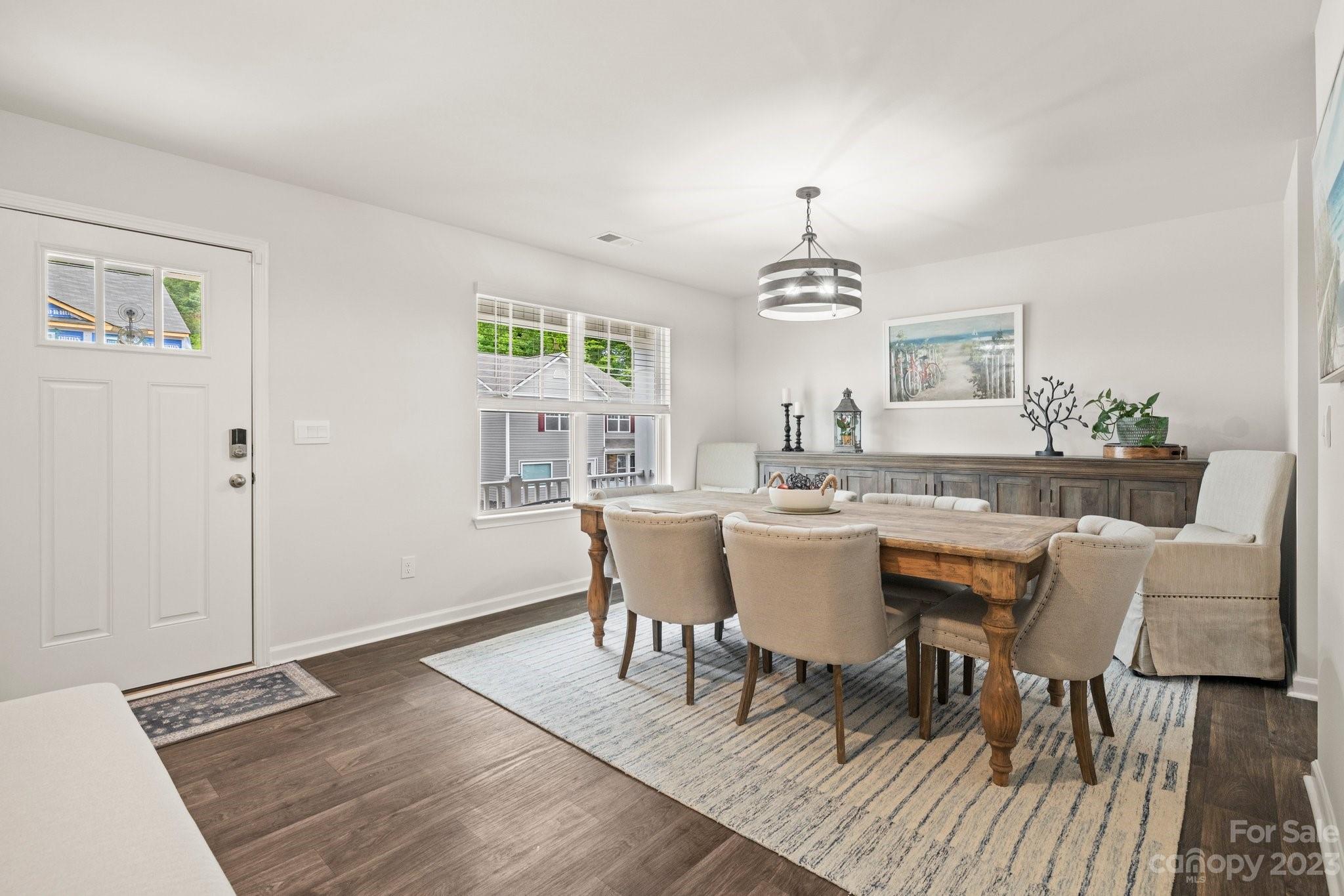 38 Hamrick Drive Candler, NC 28715 - Photo 9 of 37 a dining room with wooden floor a chandelier a wooden table and chairs