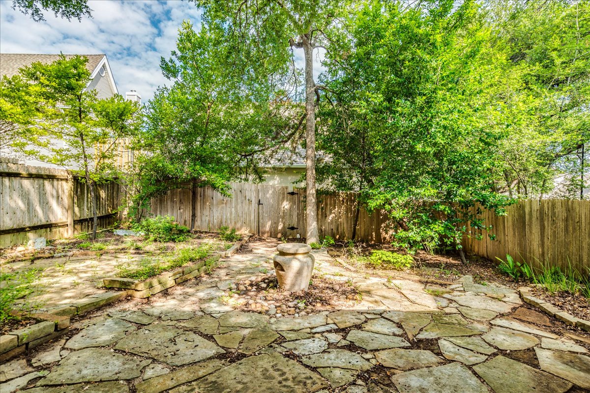 3809 Spicewood Springs Road, Unit 127 Austin, TX 78759 - Photo 23 of 29 A private yard with a natural stone patio and lush green fencing provides a tranquil outdoor retreat.