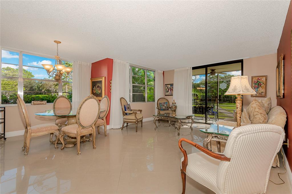 1200 St Charles Place, Unit L19 Pembroke Pines, FL 33026 - Photo 1 of 26 a living room with furniture and a large window