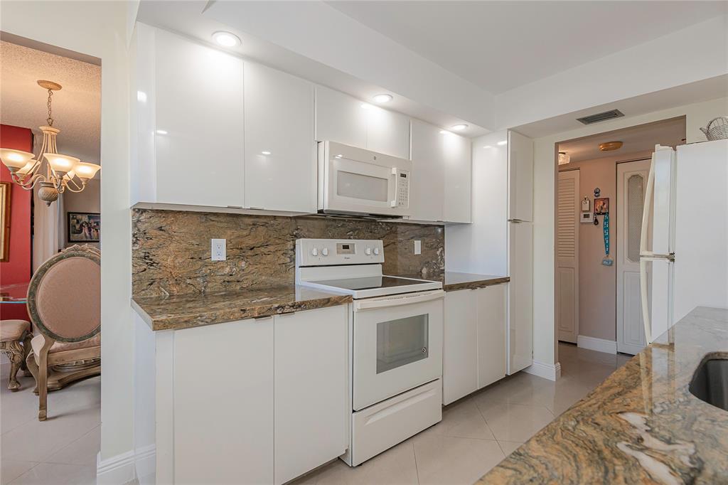 1200 St Charles Place, Unit L19 Pembroke Pines, FL 33026 - Photo 12 of 26 a kitchen with stainless steel appliances granite countertop a stove a sink and a refrigerator