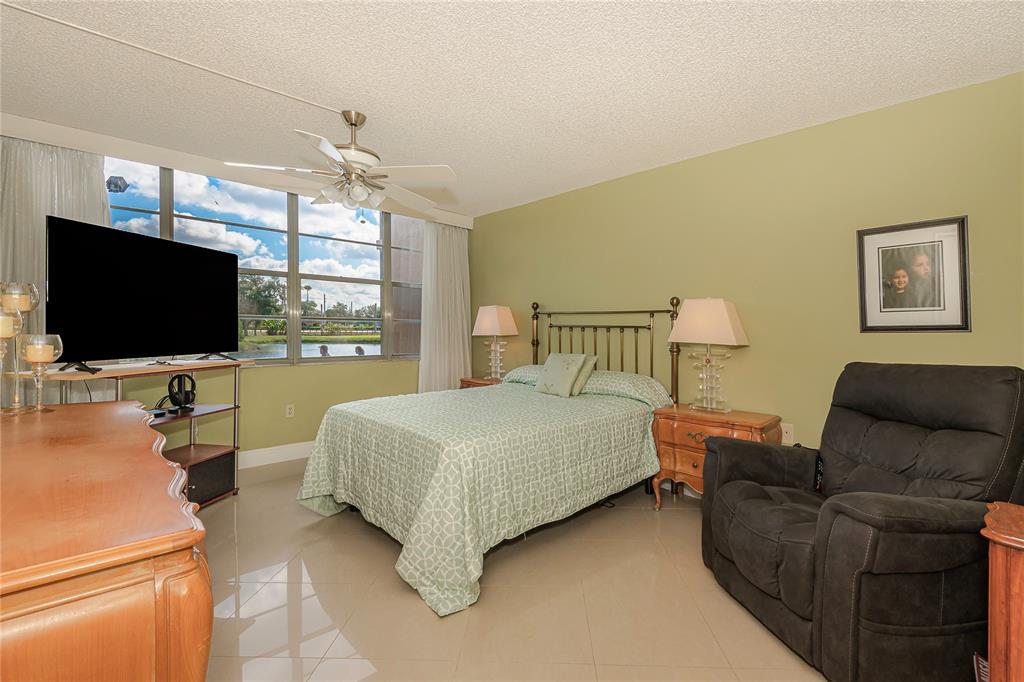 1200 St Charles Place, Unit L19 Pembroke Pines, FL 33026 - Photo 15 of 26 a bedroom with furniture and a flat screen tv