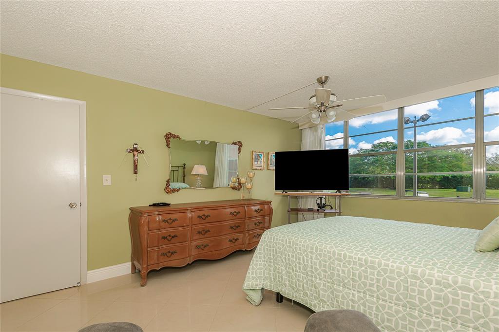 1200 St Charles Place, Unit L19 Pembroke Pines, FL 33026 - Photo 23 of 26 a bedroom with a bed and flat screen tv