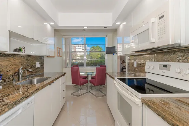 a kitchen with granite countertop a sink and a stove top oven