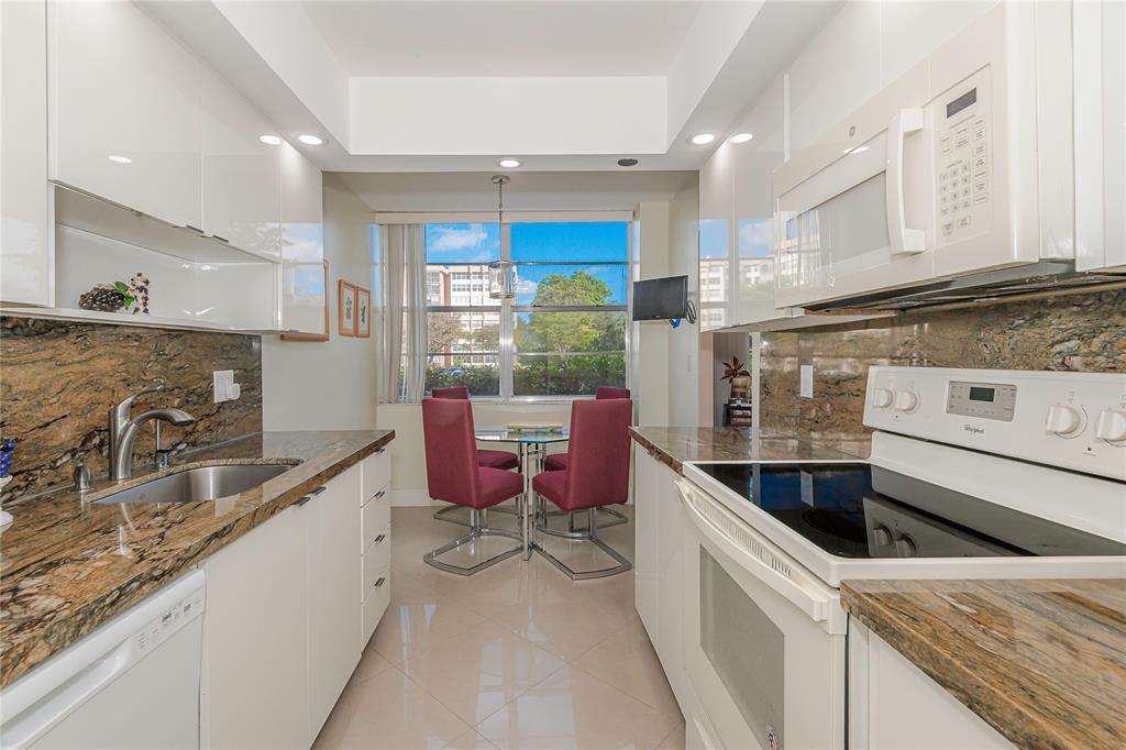 1200 St Charles Place, Unit L19 Pembroke Pines, FL 33026 - Photo 10 of 26 a kitchen with granite countertop a sink and a stove top oven