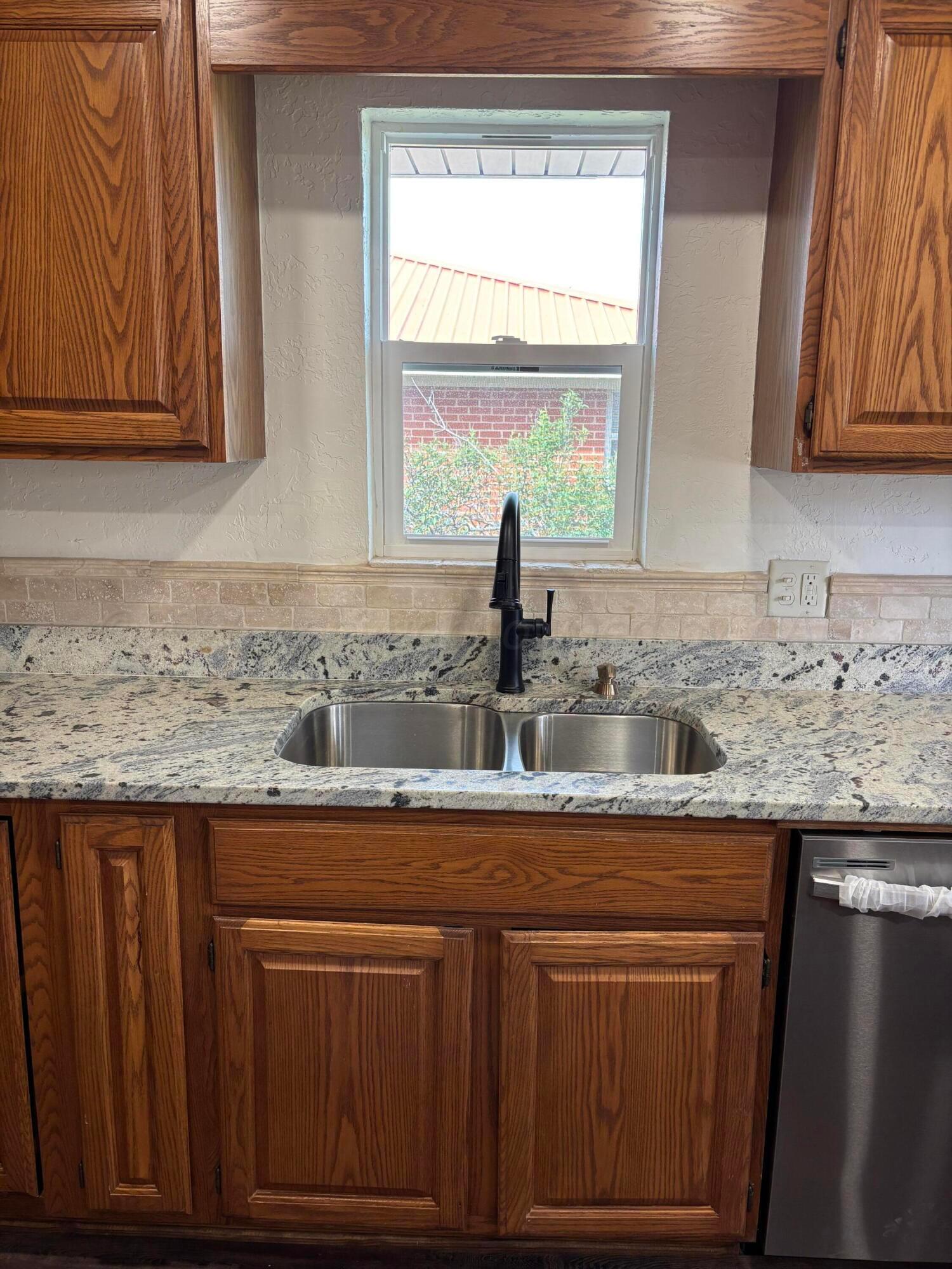 214 East Wichita Street Miami, TX 79059 - Photo 12 of 18 a kitchen with granite countertop cabinets sink and window