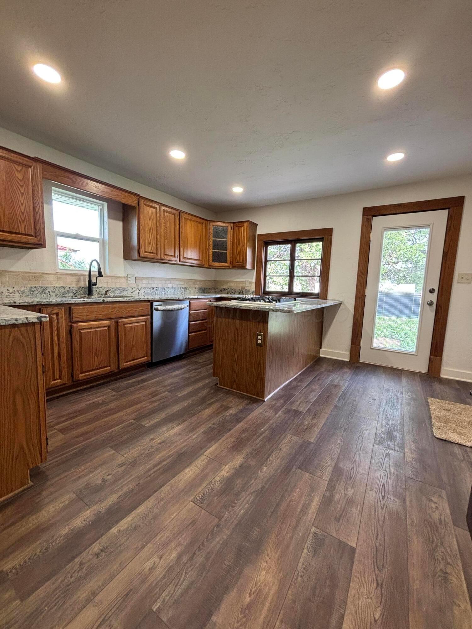 214 East Wichita Street Miami, TX 79059 - Photo 13 of 18 a large kitchen with lots of counter space a sink dishwasher and a stove with wooden floor