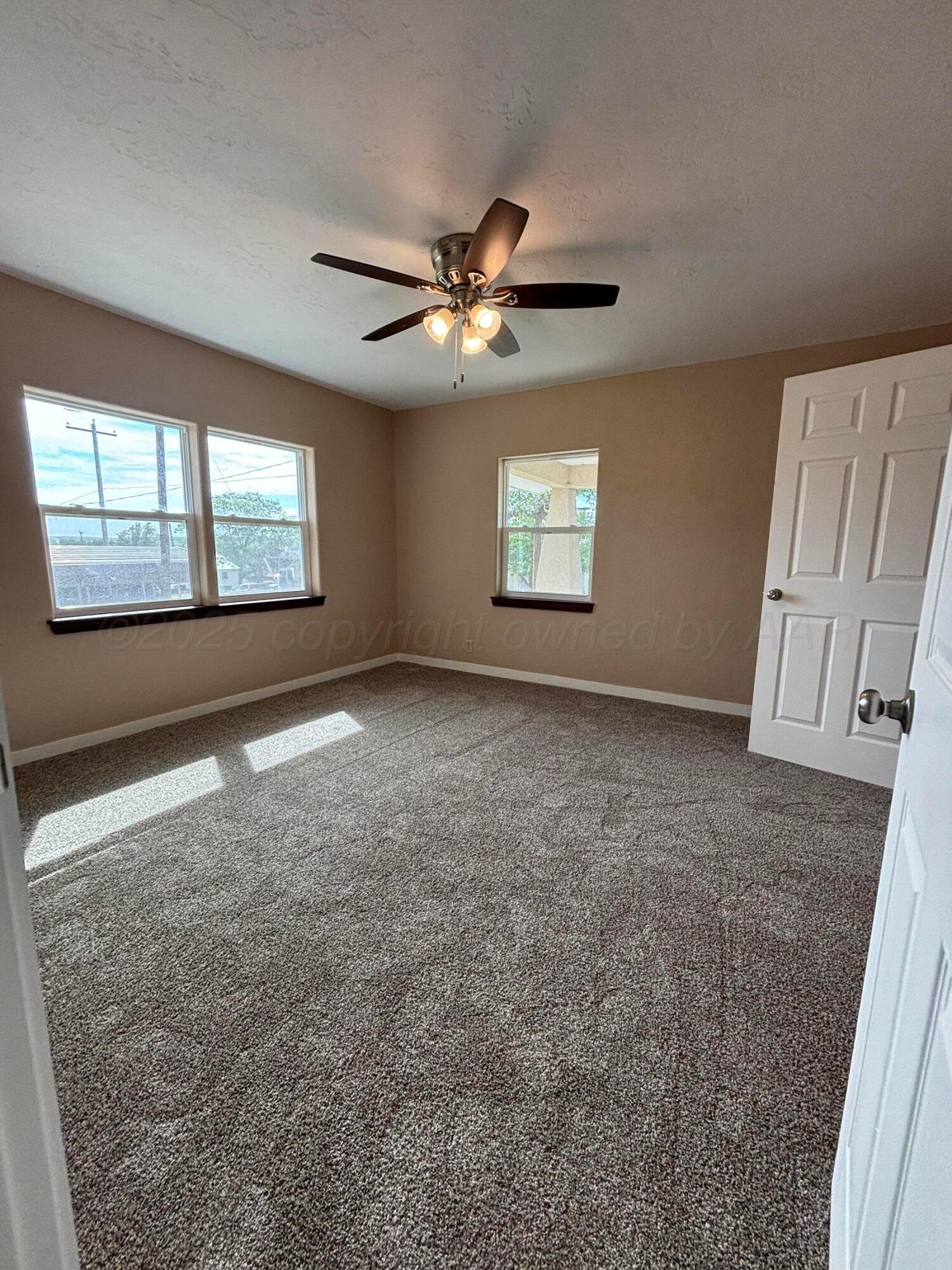 214 East Wichita Street Miami, TX 79059 - Photo 5 of 18 an empty room with windows and fan