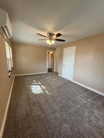 an empty room with a ceiling fan and window