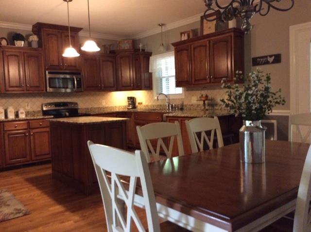 1109 Loftin Road Columbia, TN 38401 - Photo 7 of 18 a kitchen with stainless steel appliances granite countertop a stove a sink dishwasher a dining table and chairs with wooden floor