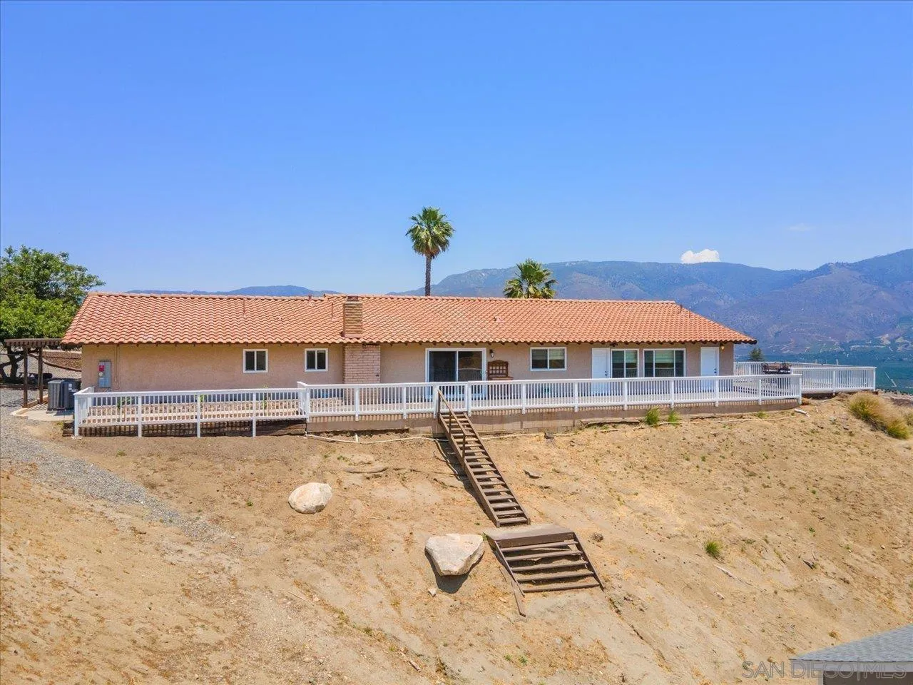 32251 Cole Grade Road Valley Center, CA 92082 - Photo 48 of 54 a view of a swimming pool with a lawn chairs under an umbrella