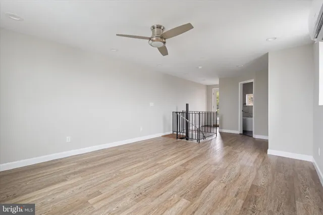 a view of a livingroom with wooden floor and a ceiling fan